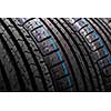 Stack of brand new high performance car tires on clean high-key white studio background