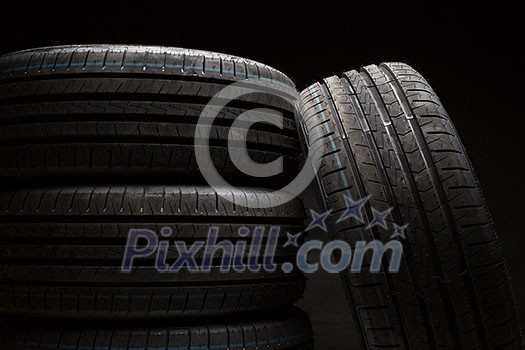 Stack of brand new high performance car tires on clean high-key white studio background Stack of brand new high performance car tires on clean high-key white studio background