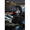 Inside a garage - modern car waiting for the mechanic to change its wheels/tires (shallow DOF; color toned image)