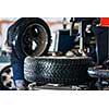 Inside a garage - modern car waiting for the mechanic to change its wheels/tires (shallow DOF; color toned image)