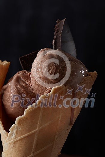Melting chocolate ice cream with pieces of chocolate in a waffle cone Melting chocolate ice cream with pieces of chocolate in a waffle cone