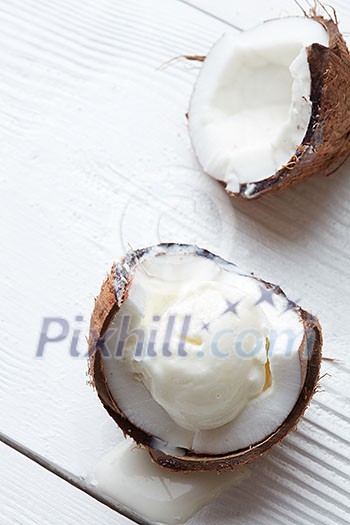 Half of coconut with fresh ice cream ball On a wooden white background Half of coconut with fresh ice cream ball On a wooden white background