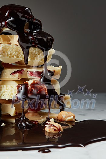 melted chocolate is poured on a stack of slices of white chocolate melted chocolate is poured on a stack of slices of white chocolate
