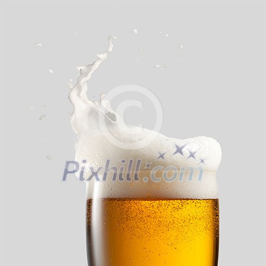 Close-up of cold beer with foam and splash on a gray background Close-up of cold beer with foam and splash on a gray background