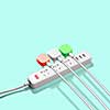 Three electrical plugs connected to a power strip or extension strip on a green background