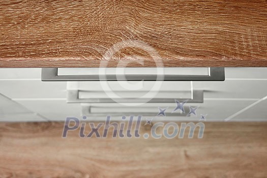 Top view of a white kitchen cupboard with a brown top Top view of a white kitchen cupboard with a brown top