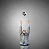 Businessman in suit catching soccer ball in jump
