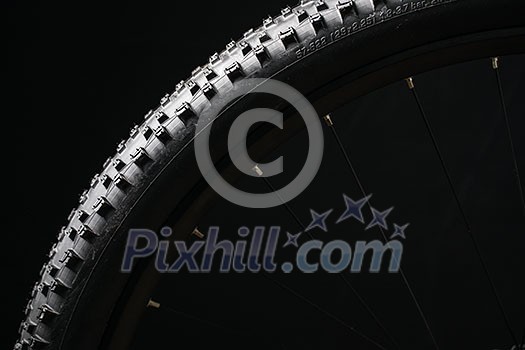 Modern MTB race mountain bike tyre isolated on black background in a studio Modern MTB race mountain bike tyre isolated on black background in a studio