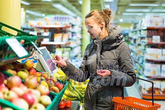 Beautiful, young woman shopping for fruits and vegetables in produce department of a grocery store/supermarket (shallow DOF; color toned image) Beautiful, young woman shopping for fruits and vegetables in produce department of a grocery store/supermarket (shallow DOF; color toned image)