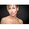 Portrait of a smiling middle aged caucasian woman against dark background - radiating confidence and feminity (shallow DOF; color toned image)