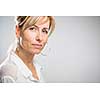 Portrait of a smiling middle aged caucasian woman against light grey background - radiating confidence and feminity (shallow DOF; color toned image)