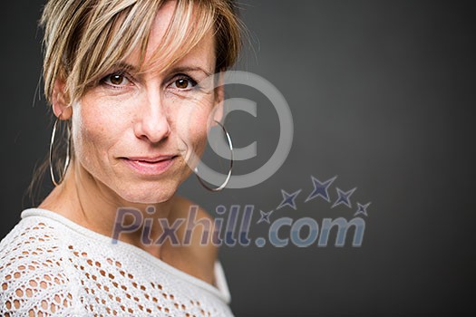 Portrait of a smiling middle aged caucasian woman against grey background (shallow DOF; color toned image) Portrait of a smiling middle aged caucasian woman against grey background (shallow DOF; color toned image)