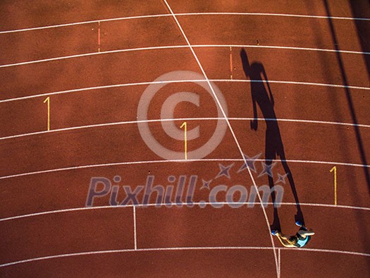 Shot of a young male athlete training on a race track. Sprinter running on athletics tracks. Shot of a young male athlete training on a race track. Sprinter running on athletics tracks.