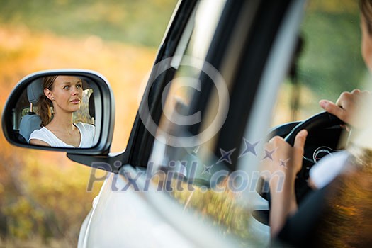Pretty, young woman driving her car - reflection in the side mirror (shallow DOF; color toned image) Pretty, young woman driving her car - reflection in the side mirror (shallow DOF; color toned image)