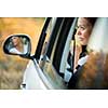 Pretty, young woman  driving her car - reflection in the side mirror (shallow DOF; color toned image)