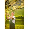 Portrait of senior man gardening, taking care of his lovely orchard, ejoying actively his retirement