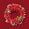 Christmas twig wreath is decorated with candy, red flowers, cookies and green leaves.