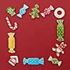 Frame of Christmas cookies of different shapes and colors on a red background