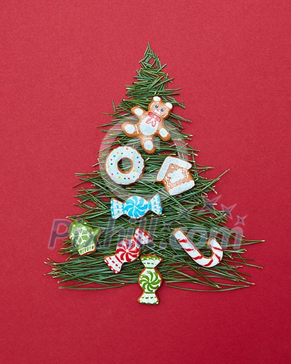 Christmas cookies decorated Christmas tree on a red background. Postcard Happy New Year. Christmas cookies decorated Christmas tree on a red background. Postcard Happy New Year.