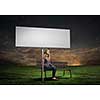 Young girl in casual with white banner sitting on bench. Place for text