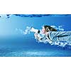 Young businesswoman in suit swimming in crystal blue water