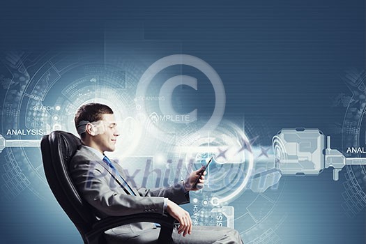 Young businessman sitting in chair behind media screen Young businessman sitting in chair behind media screen