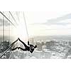 Concept of competition with businessman climbing office building with rope