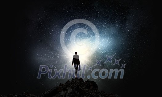 Rear view of businesswoman standing on top and looking in sky Rear view of businesswoman standing on top and looking in sky