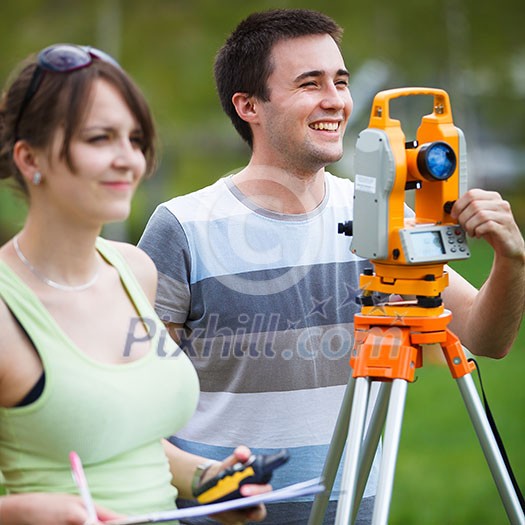 Two young land surveyors at work Two young land surveyors at work