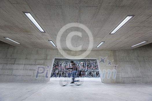 Modern trainstation with bikestands rush - man walking to get his bike and commute home (color toned image;motion blurred image) Modern trainstation with bikestands rush - man walking to get his bike and commute home (color toned image;motion blurred image)