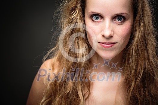 Studio glamour portrait of a pretty, young woman with lovely curly hair