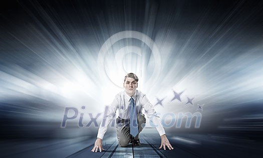 Young determined businessman in starting position ready to compete Young determined businessman in starting position ready to compete