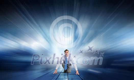 Young determined businessman in starting position ready to compete