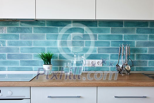 Modern white kitchen at home with utensils on the background of blue tiles Modern white kitchen at home with utensils on the background of blue tiles