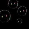 Rainbow soap bubbles on a dark background.