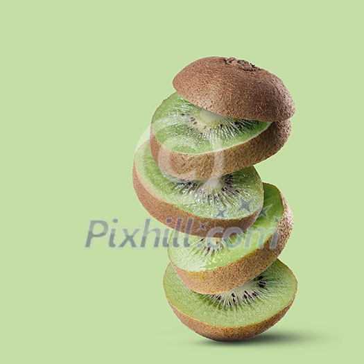 flying slices pieces of green ripe kiwi on a green background flying slices pieces of green ripe kiwi on a green background