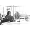 Full length of a relaxed casual young businessman sitting with legs on desk at office