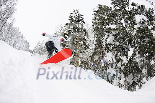 Snowboarder doing a jump and free ride on  powder snow at winter season