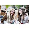 very cute smiling women drinking a coffee sitting inside in cafe restaurant