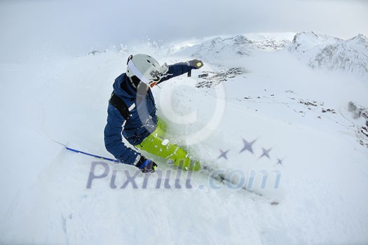 skier skiing downhill on fresh powder snow with sun and mountains in background skier skiing downhill on fresh powder snow with sun and mountains in background