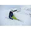 skier skiing downhill on fresh powder snow  with sun and mountains in background