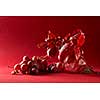 grape branches in a glass vase and a bunch of grapes on a red background