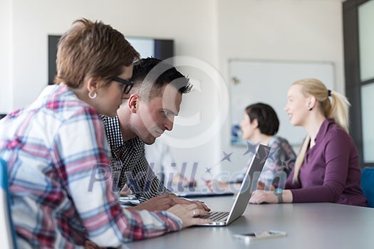 young startup business people, couple working on laptop computer, businesspeople group on meeting in background at office interior young startup business people, couple working on laptop computer, businesspeople group on meeting in background at office interior