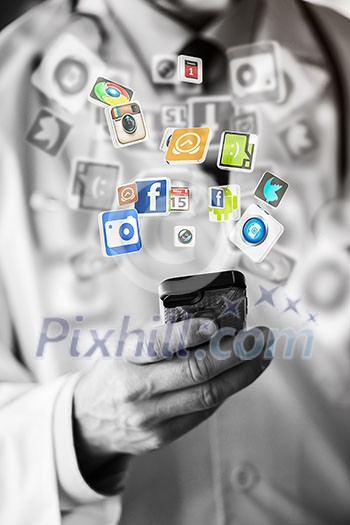 Hand holding smart phone and social network icons flying Hand holding smart phone and social network icons flying
