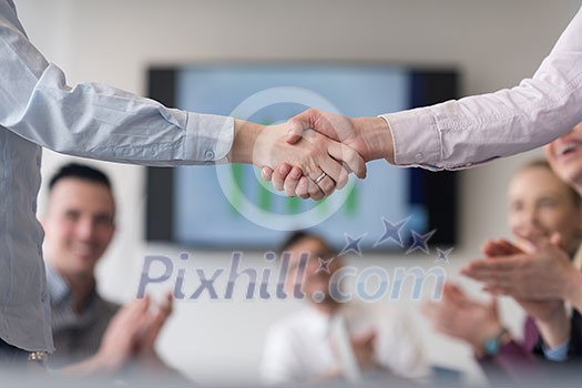 businesswomans handshake on team meeting with group of people blured in background at modern startup business office interior businesswomans handshake on team meeting with group of people blured in background at modern startup business office interior