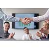 businesswomans handshake on team meeting  with group of people blured in background at modern startup business office interior