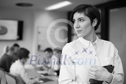 businesswoman on meeting using tablet computer blured group of business people in background at modern bright startup office interior businesswoman on meeting using tablet computer blured group of business people in background at modern bright startup office interior