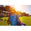 handsome middle eastern golf player carrying and bag and walking at course on beautiful morning sunrise