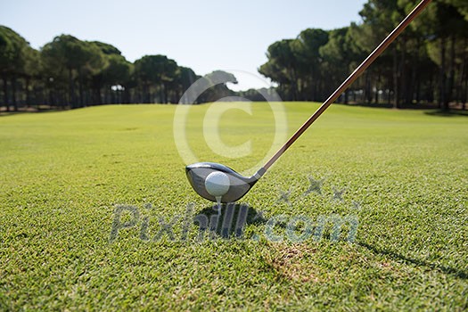 golf player placing ball on tee. beautiful sunrise on golf course landscape in background golf player placing ball on tee. beautiful sunrise on golf course landscape in background