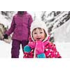 portrait of happy smiling little girl child outdoors having fun and playing on snowy winter day